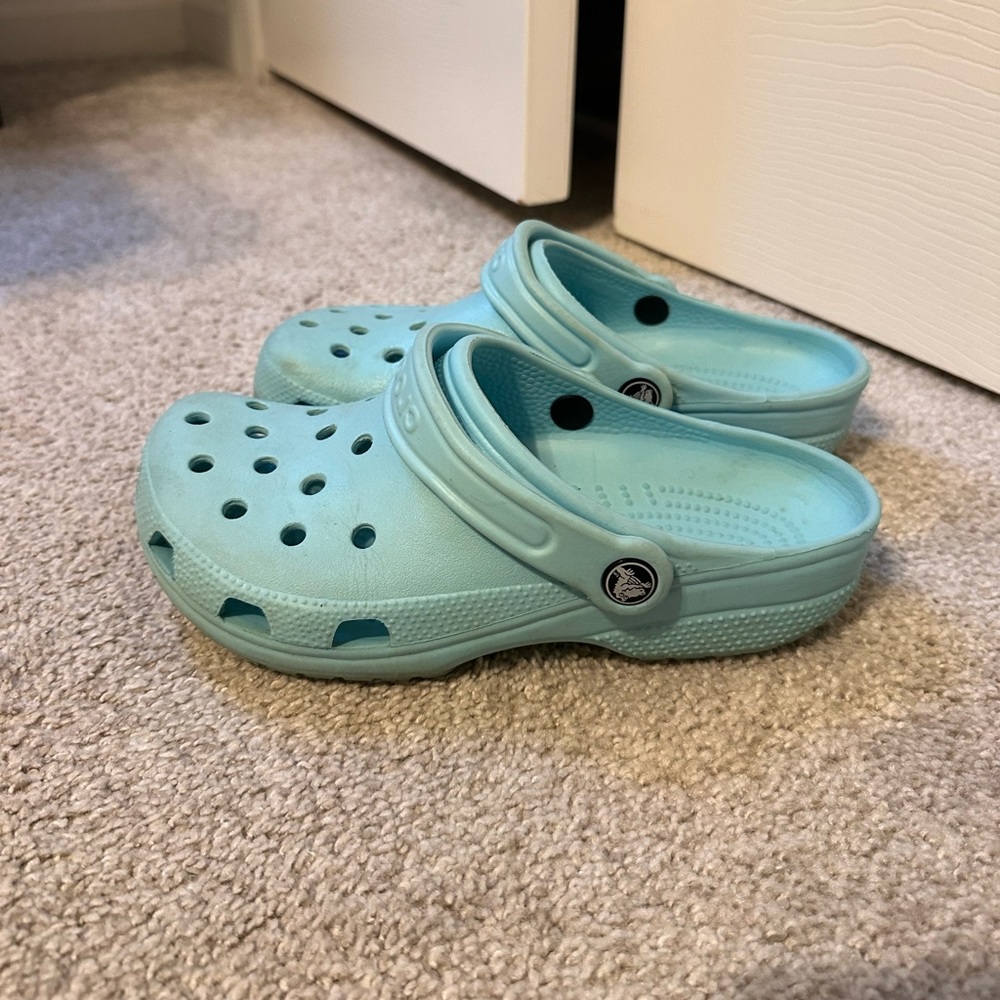 Teal Crocs. Women’s size 7. Good condition; does have some creases.